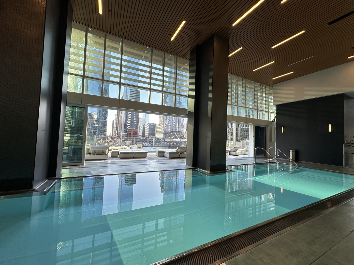 313 West Wolf Point Plaza, Unit 1910 Chicago, IL 60654 - Photo 19 of 30 a living room with pool table and chairs next to a large window
