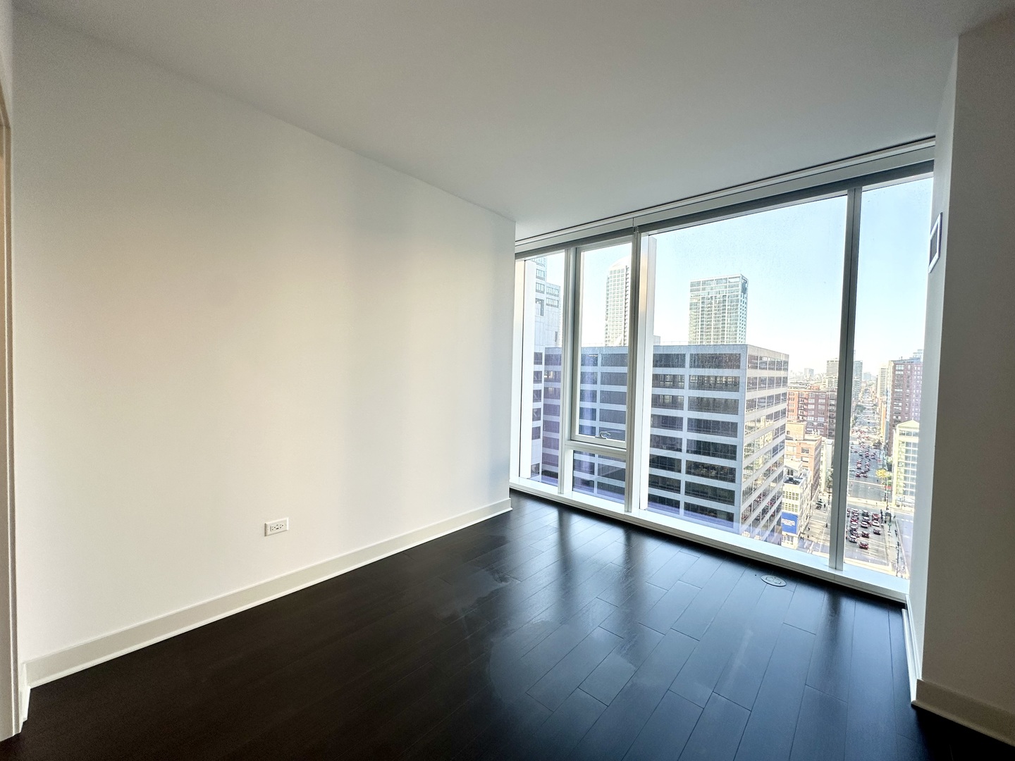 313 West Wolf Point Plaza, Unit 1910 Chicago, IL 60654 - Photo 7 of 30 wooden floor in an empty room with a window