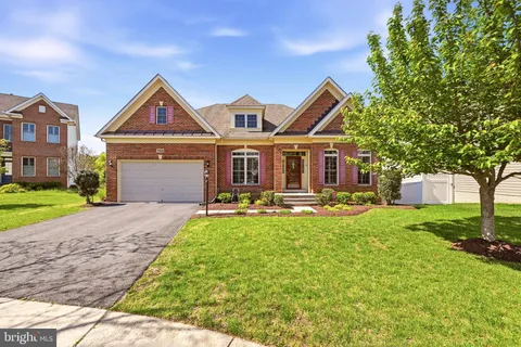 a front view of a house with yard and green space