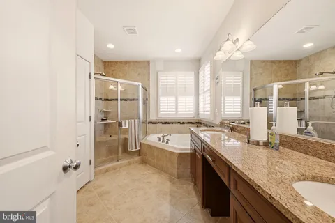 a large bathroom with a granite countertop sink mirror bathtub and shower