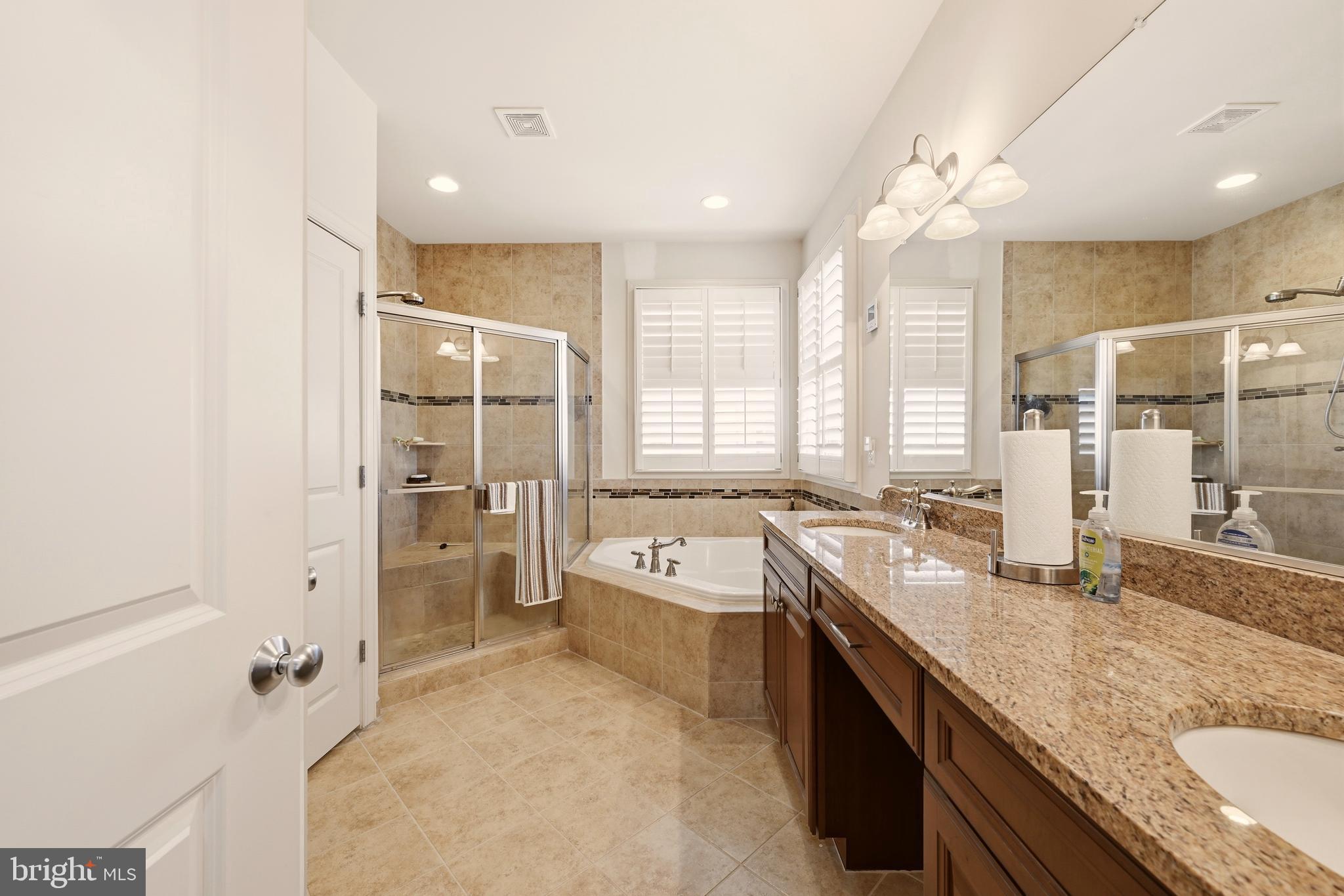 1104 Sweetbay Place Silver Spring, MD 20906 - Photo 22 of 43 a large bathroom with a granite countertop sink mirror bathtub and shower