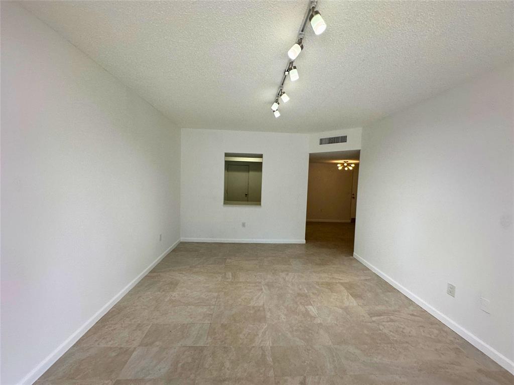 50 Southwest 3rd Avenue, Unit 110 Boca Raton, FL 33432 - Photo 9 of 21 an empty room with chandelier fan and windows