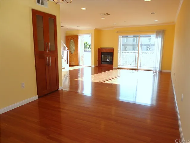 a view of empty room with wooden floor and fireplace