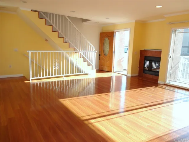 an empty room with wooden floor and a bathroom
