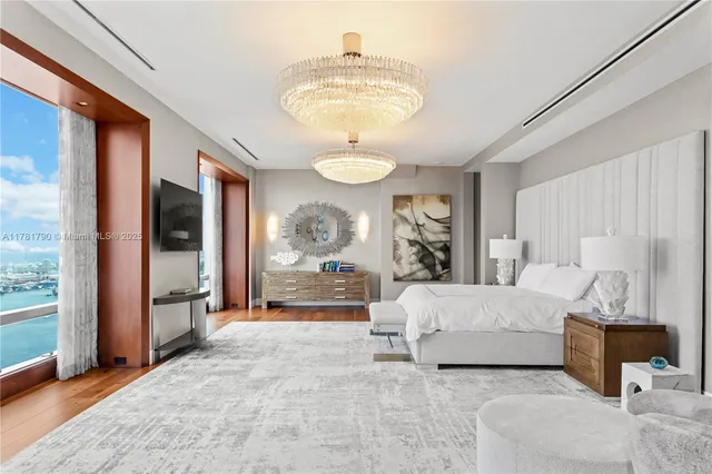 a spacious bedroom with a bed and a chandelier