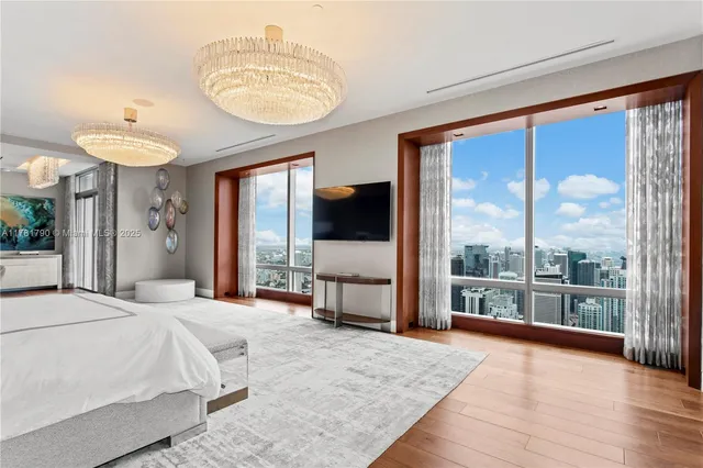 a bedroom with a large bed and a chandelier