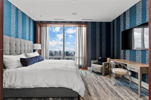 a large bedroom with a bed and large window