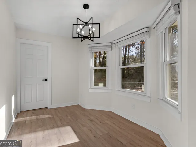 an empty room with windows and cabinet