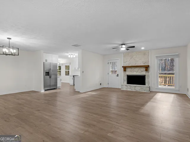 a view of empty room with wooden floor and fireplace