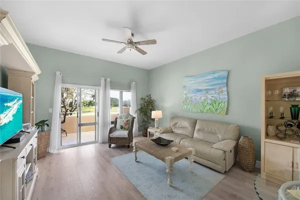 a living room with furniture a ceiling fan and a flat screen tv