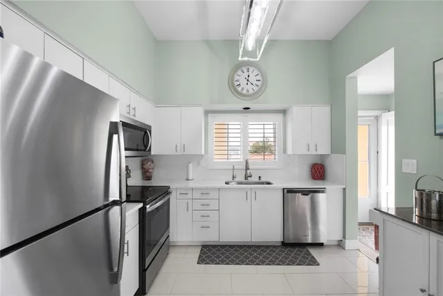a kitchen with stainless steel appliances a refrigerator a sink and cabinets