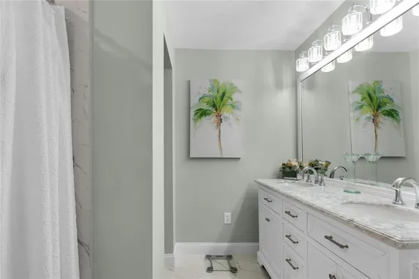 a bathroom with a granite countertop sink a potted plant and a mirror