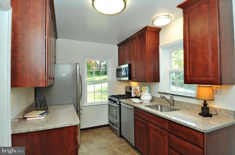 9518 St Andrews Way Silver Spring, MD 20901 - Photo 11 of 29 a kitchen with sink a window and cabinets