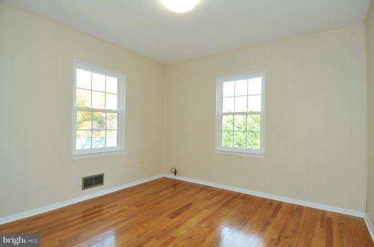 9518 St Andrews Way Silver Spring, MD 20901 - Photo 16 of 29 an empty room with wooden floor and windows