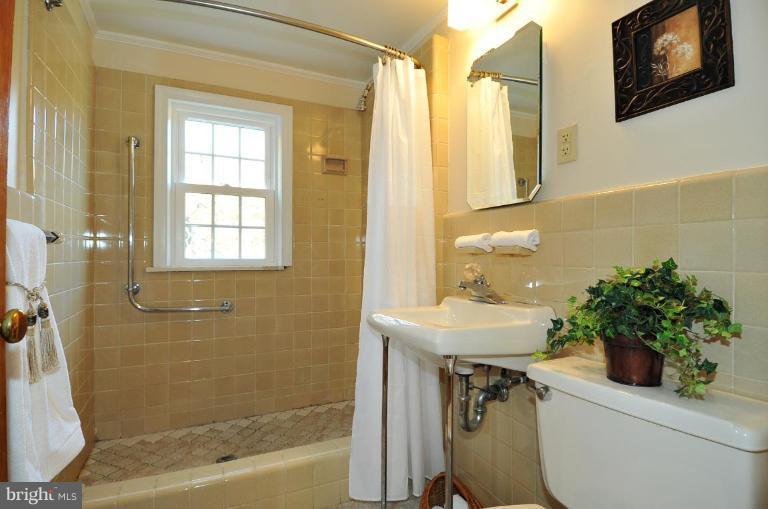 9518 St Andrews Way Silver Spring, MD 20901 - Photo 20 of 29 a bathroom with a sink a toilet and shower