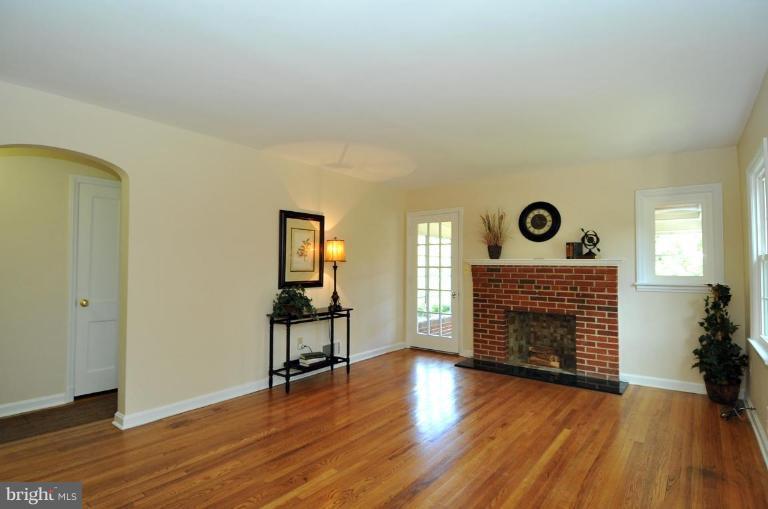 9518 St Andrews Way Silver Spring, MD 20901 - Photo 6 of 29 an empty room with wooden floor fireplace and windows