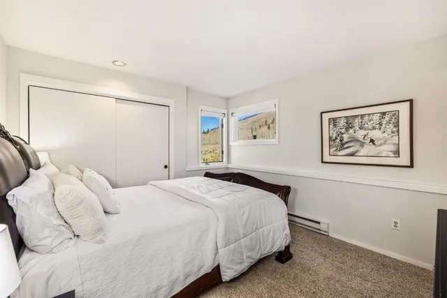 a bedroom with a bed and a painting on the wall