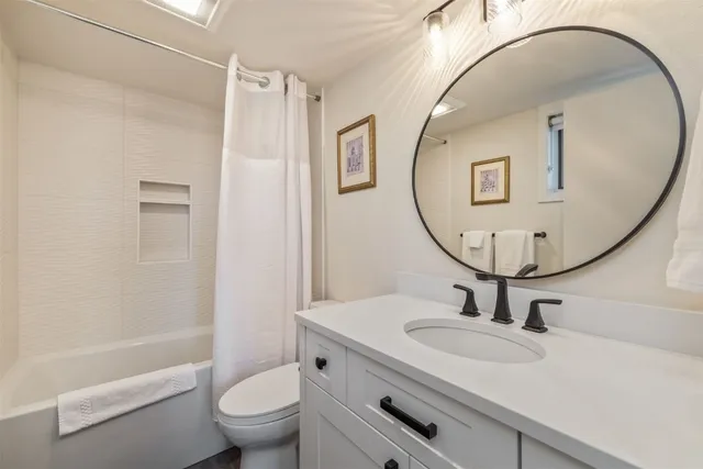 a bathroom with a sink a mirror a toilet and a mirror