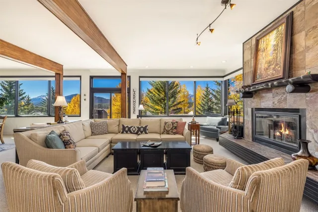 a living room with furniture fireplace and a large window
