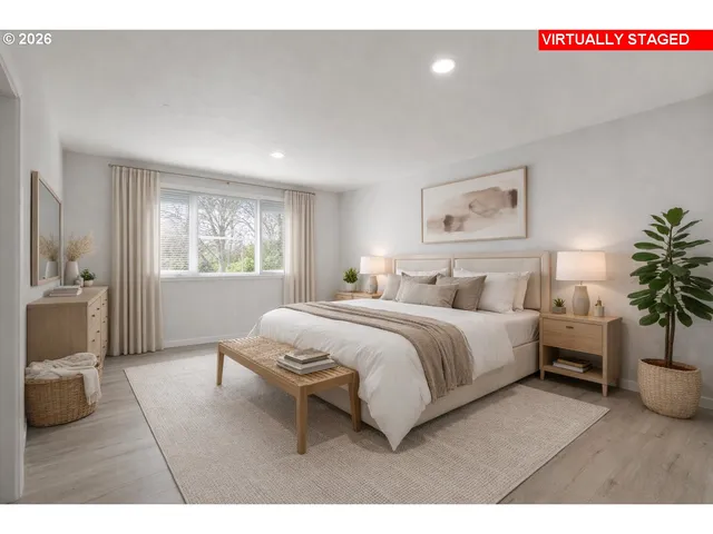 a spacious bedroom with a bed a couch and potted plant