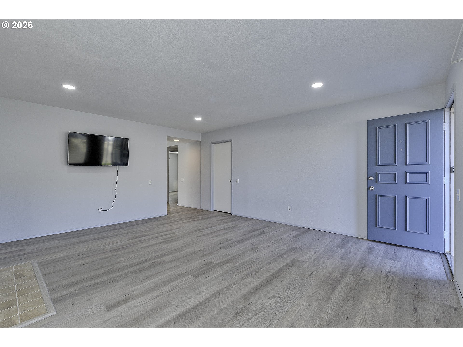 15765 Southwest Highland Court Portland, OR 97224 - Photo 4 of 30 a view of an empty room with wooden floor and a kitchen