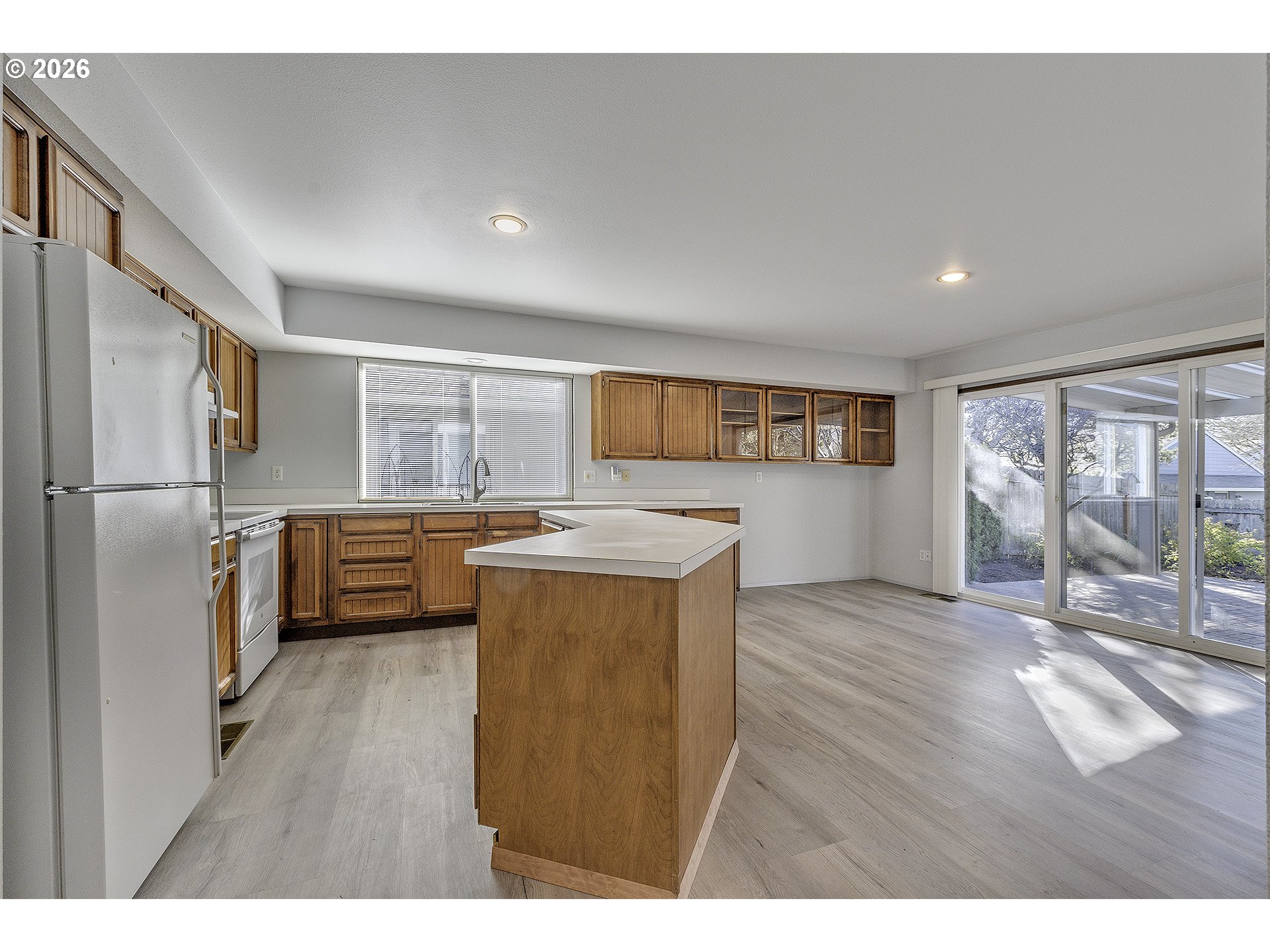 15765 Southwest Highland Court Portland, OR 97224 - Photo 6 of 30 a kitchen with stainless steel appliances a refrigerator and a wooden floor