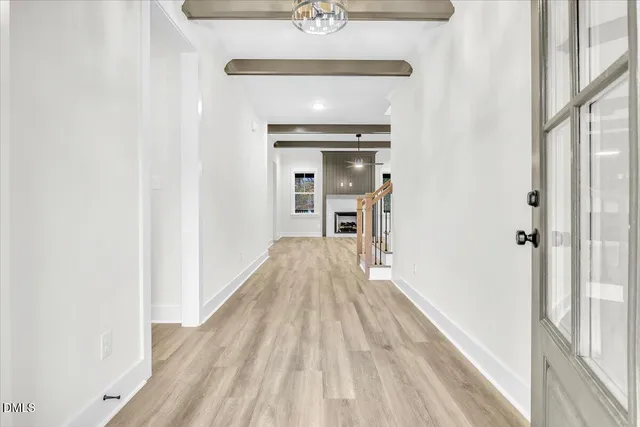 a view of a hallway with wooden floor and staircase