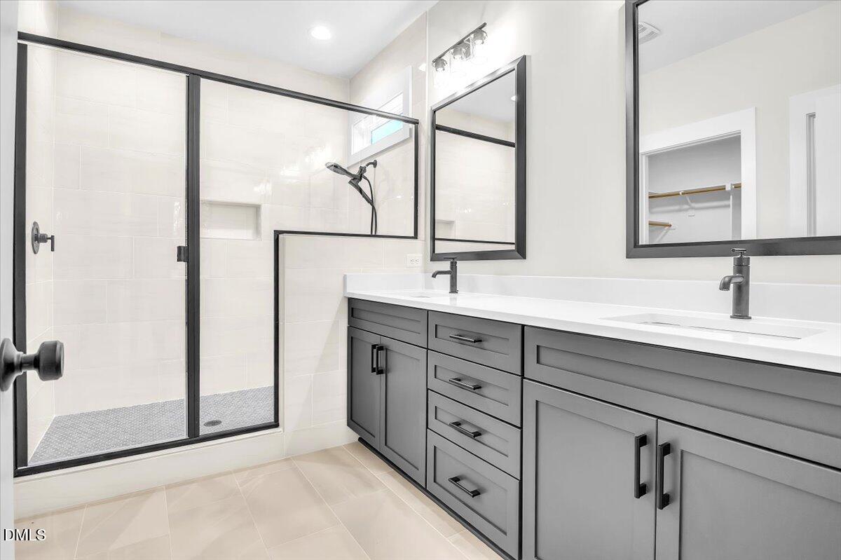 12916 Mallard Rock Road Zebulon, NC 27597 - Photo 21 of 68 a bathroom with a double vanity sink and mirror