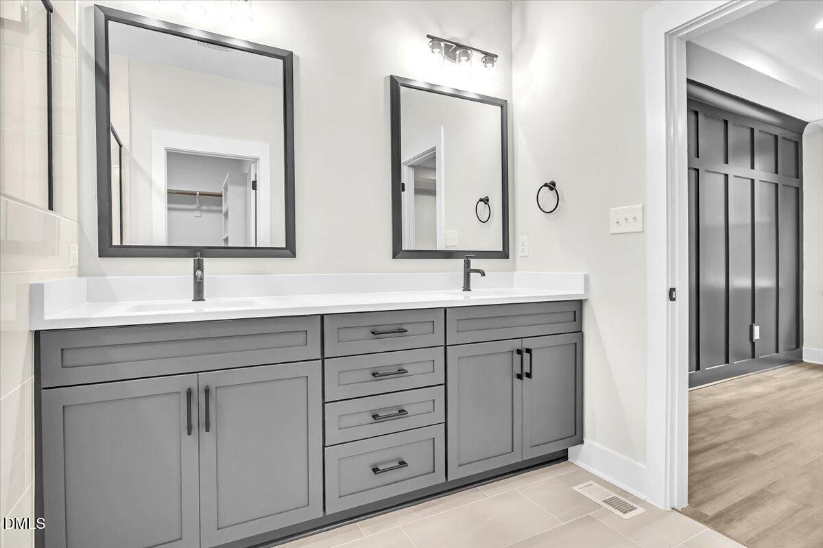 12916 Mallard Rock Road Zebulon, NC 27597 - Photo 22 of 68 a bathroom with double sink and a mirror