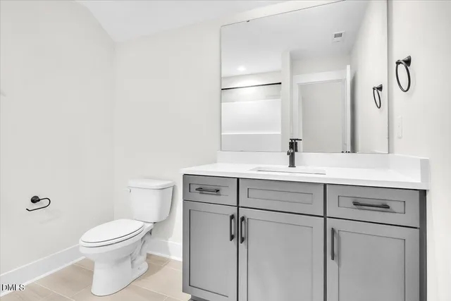 a view of an empty room with wooden floor fireplace and a window