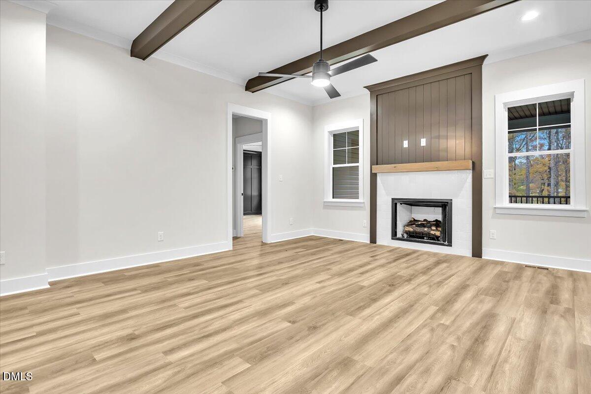 12916 Mallard Rock Road Zebulon, NC 27597 - Photo 66 of 68 a view of an empty room with wooden floor fireplace and a window