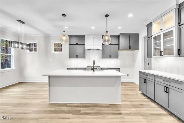 a large white kitchen with stainless steel appliances kitchen island granite countertop a sink stove and refrigerator