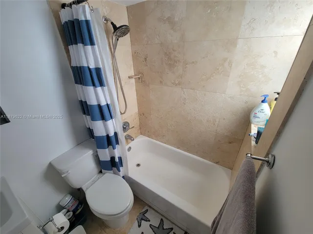 a bathroom with a sink a toilet a tub and shower