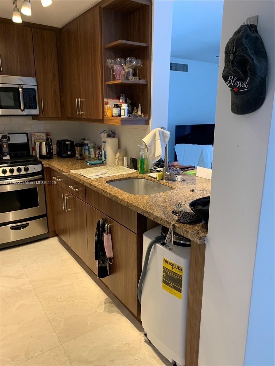 3304 Virginia Street, Unit 6C Miami, FL 33133 - Photo 7 of 22 a kitchen with stainless steel appliances granite countertop a stove and a sink