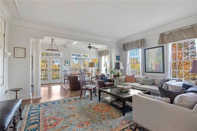 a living room with furniture wooden floor and a large window