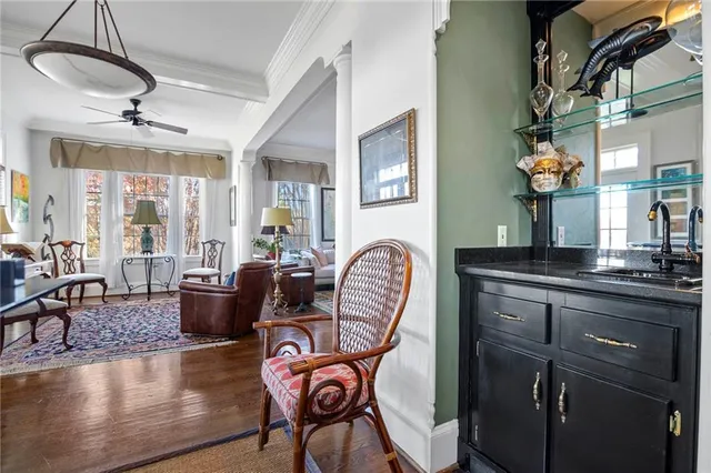 a living room with furniture a chandelier and wooden floor