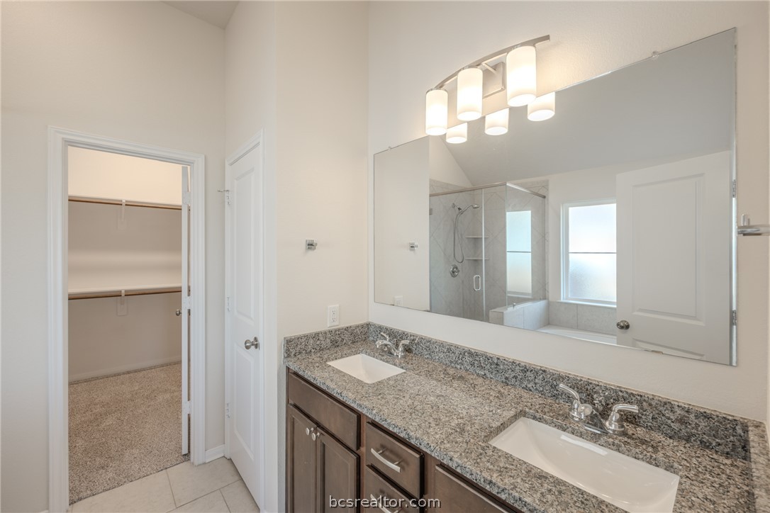 1012 Old Vine Road Brenham, TX 77833 - Photo 17 of 22 a bathroom with a granite countertop sink and a mirror