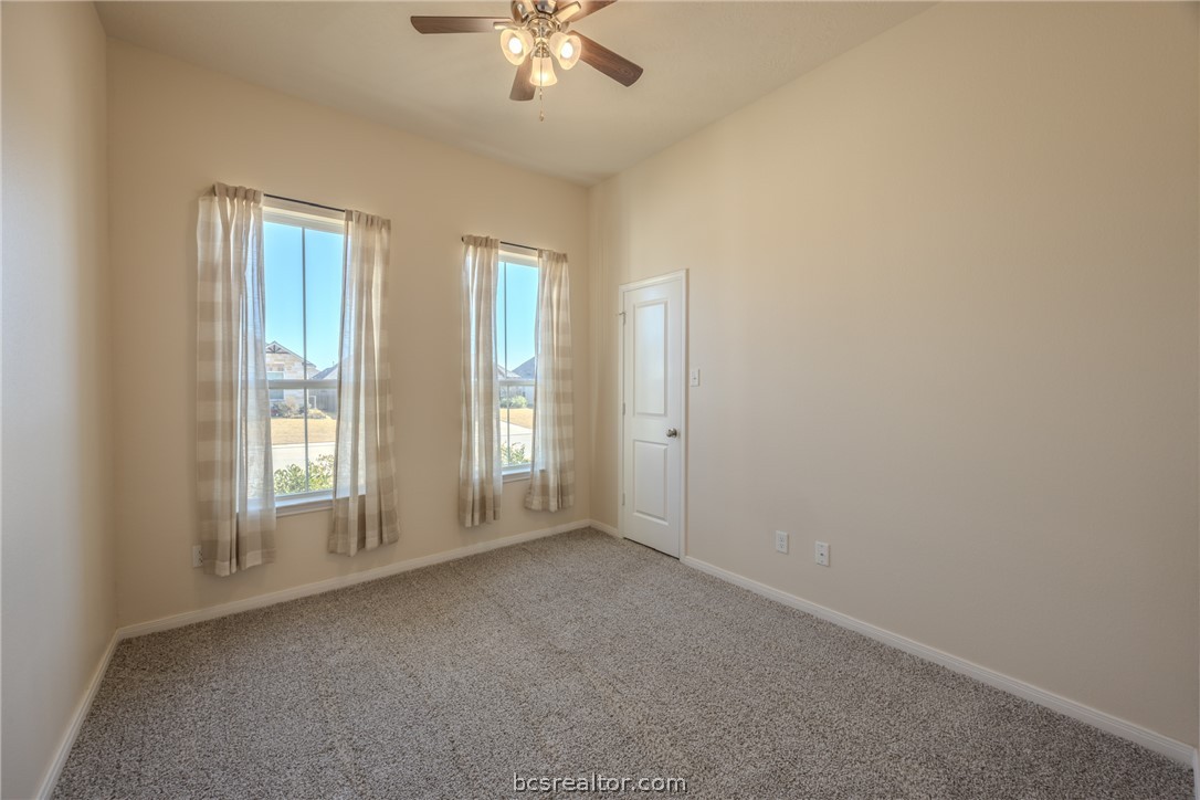 1012 Old Vine Road Brenham, TX 77833 - Photo 19 of 22 an empty room with chandelier fan and windows