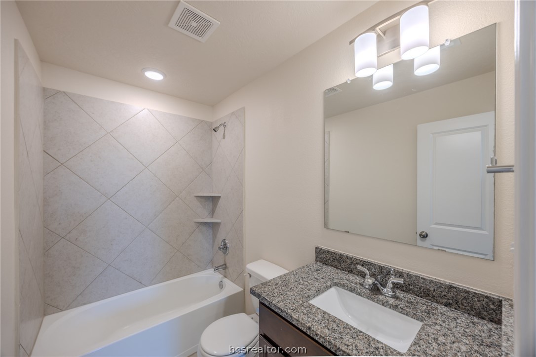 1012 Old Vine Road Brenham, TX 77833 - Photo 20 of 22 a bathroom with a granite countertop sink and a mirror
