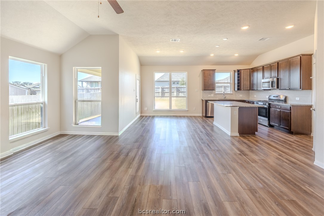 1012 Old Vine Road Brenham, TX 77833 - Photo 2 of 22 a large kitchen with a wooden floor and large windows