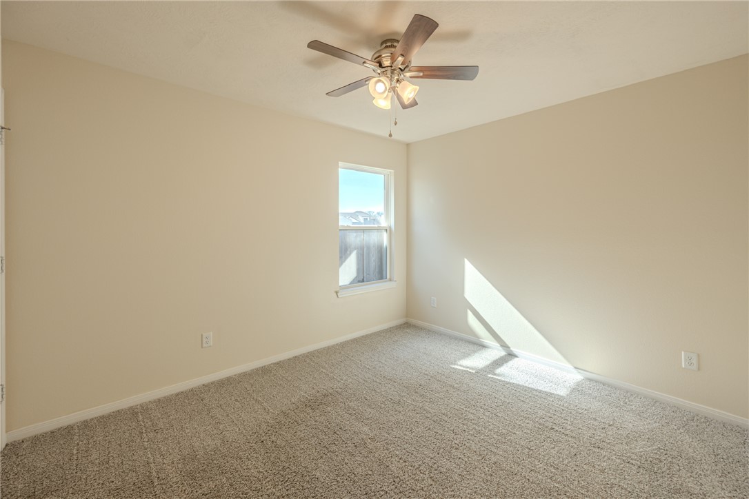 1012 Old Vine Road Brenham, TX 77833 - Photo 22 of 22 an empty room with a chandelier fan and windows