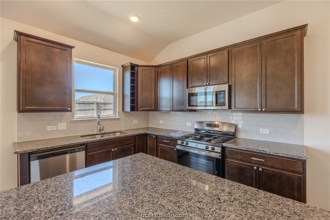 1012 Old Vine Road Brenham, TX 77833 - Photo 10 of 22 a kitchen with stainless steel appliances granite countertop a sink stove and oven