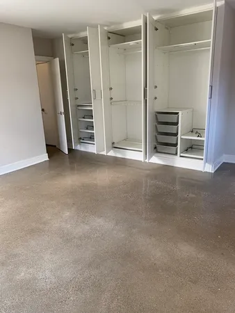 an empty room with a cabinet and mirrors