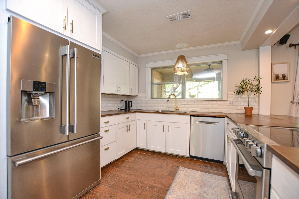 a large kitchen with stainless steel appliances granite countertop a refrigerator and a sink
