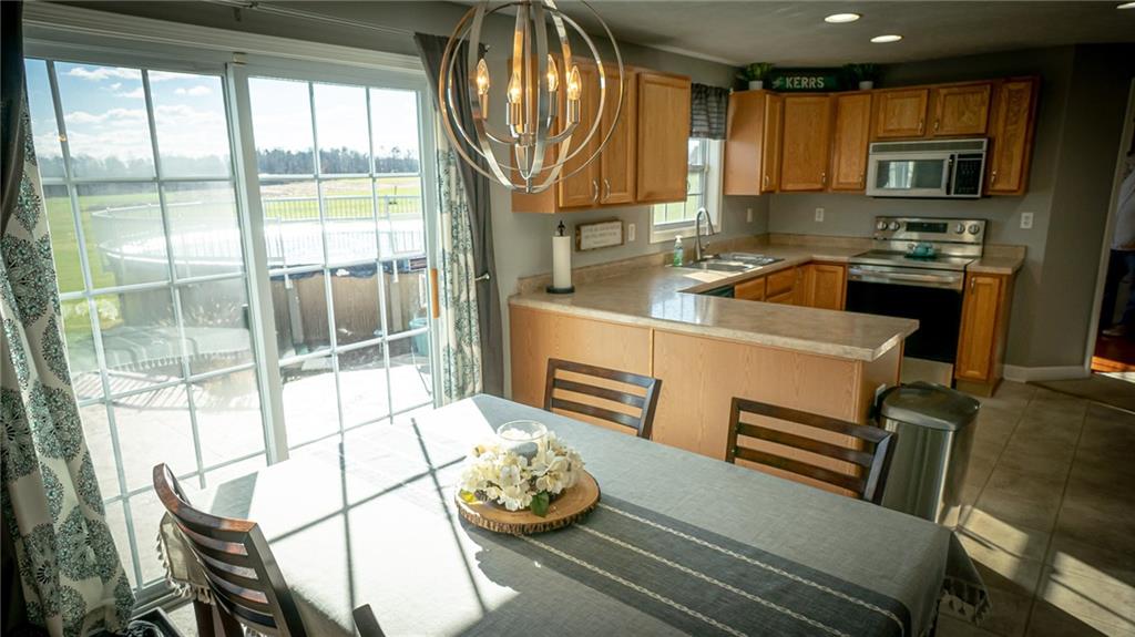 669 Unionville Road Butler, PA 16001 - Photo 6 of 21 a kitchen with a refrigerator a stove a sink and a dining table with garden view