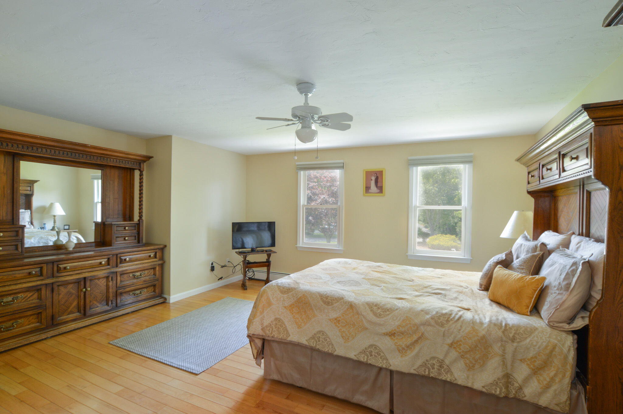 48 Hogan Drive Mashpee, MA 02649 - Photo 28 of 36 a spacious bedroom with a bed and wooden floor