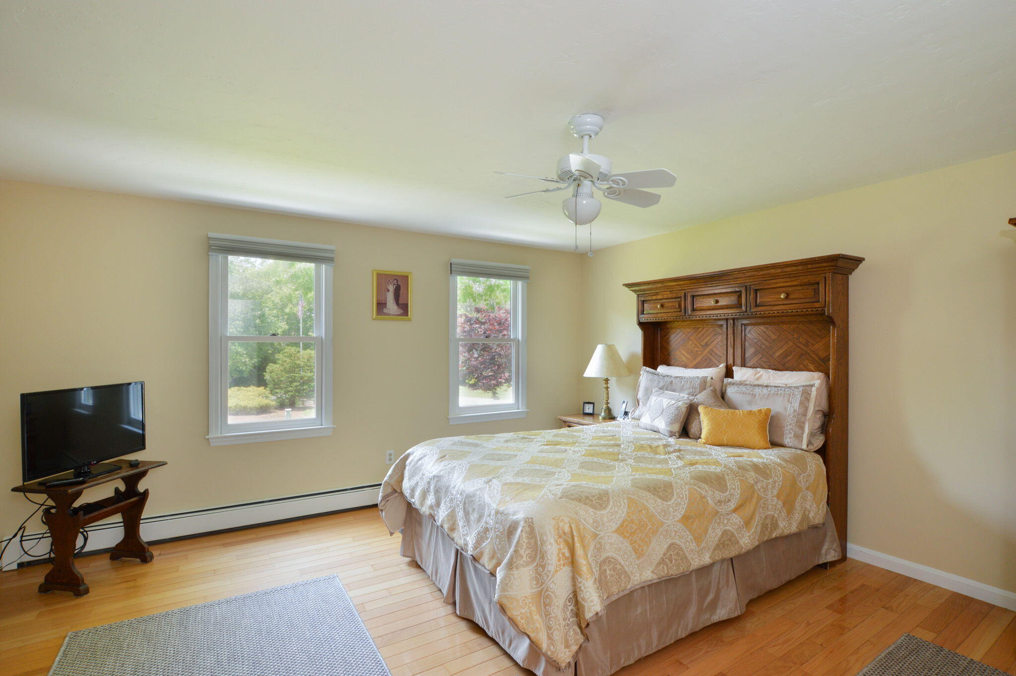 48 Hogan Drive Mashpee, MA 02649 - Photo 29 of 36 a bedroom with a bed a chair and a chandelier