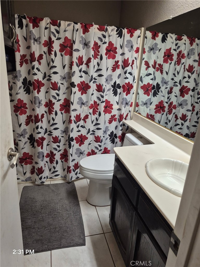 15246 Chaparral Way Victorville, CA 92394 - Photo 5 of 6 a bathroom with a sink toilet and shower curtain