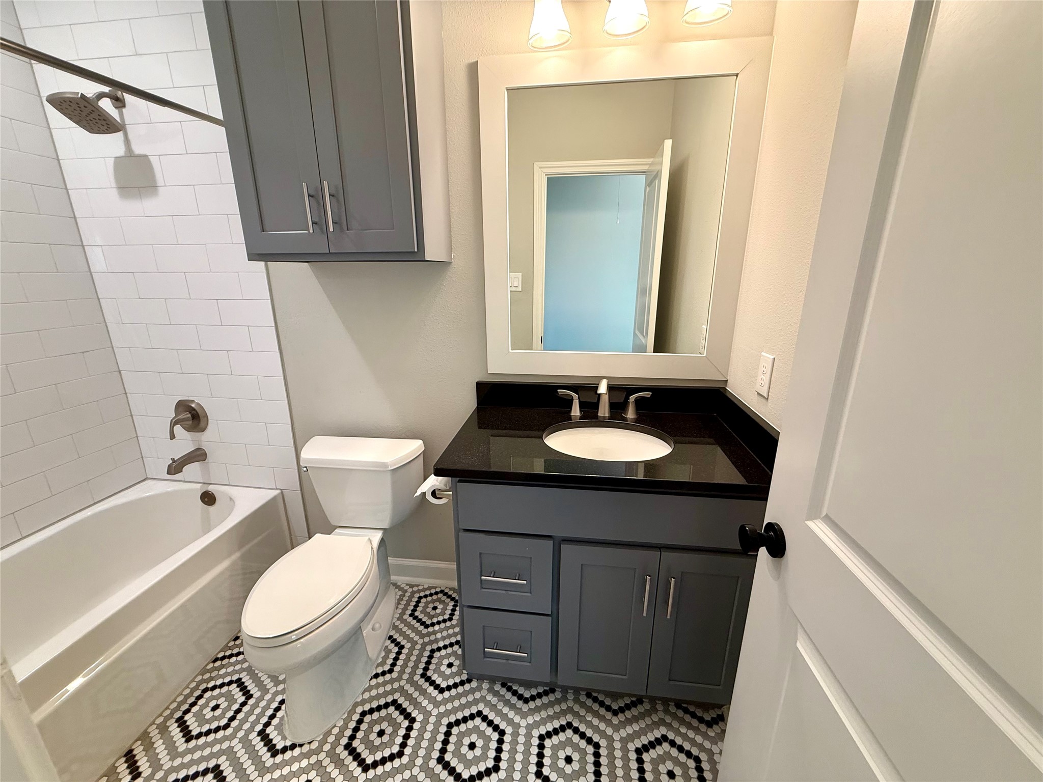 9206 Anna Street Needville, TX 77461 - Photo 19 of 24 a bathroom with a sink a toilet a mirror a vanity and bathtub