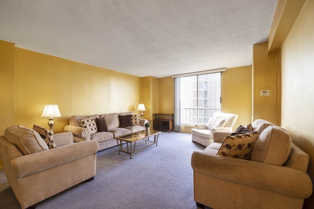 33 Pond Avenue, Unit 912 Brookline, MA 02445 - Photo 2 of 17 a living room with furniture and a large window